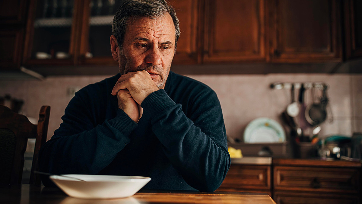 Man sitting at table looking worried